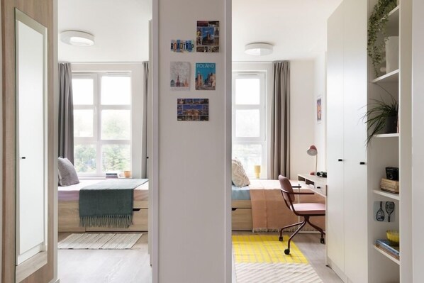 A room with a bed, desk, chair, and a bookshelf. - MILESTONE Krakow Center Student Living by Tribera (Kraków)