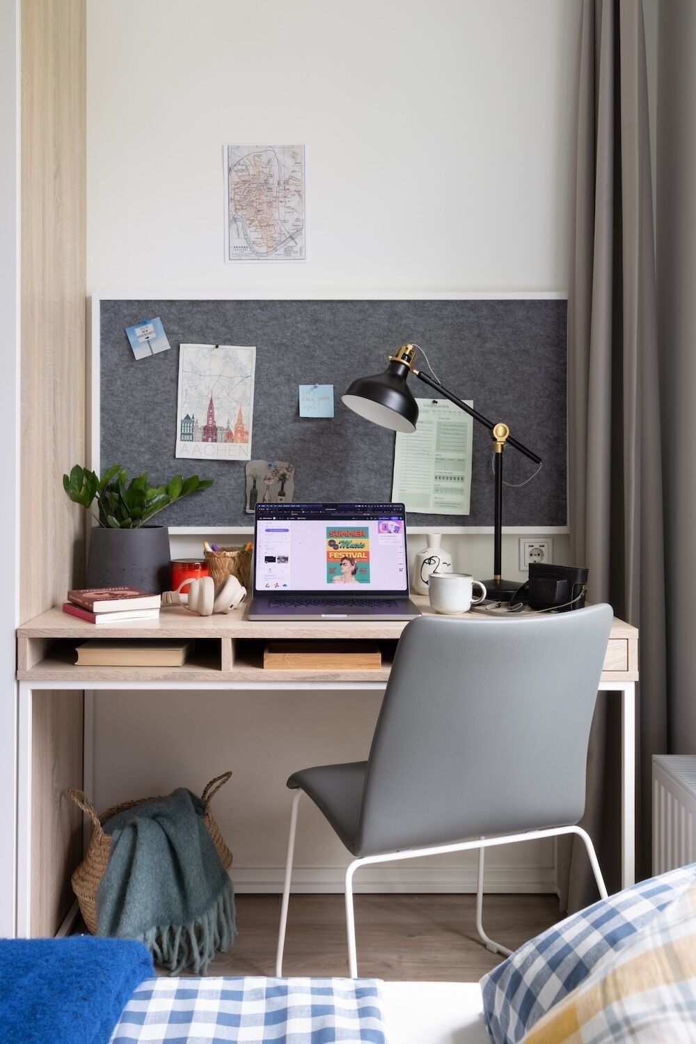 A study area with a desk, laptop, lamp, and a chair.