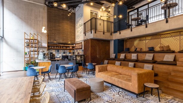 A spacious lounge area with a high ceiling, exposed beams, and a mezzanine level with seating. - w * | Cozy Loft in Parque Virrey (Bogotá)