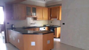 Una cocina con armarios de madera, encimera negra y una isla central.