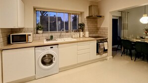 Una cucina moderna con lavatrice integrata, forno a microonde e lavello.