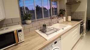 Una cucina moderna con forno a microonde, lavello e lavatrice integrata.