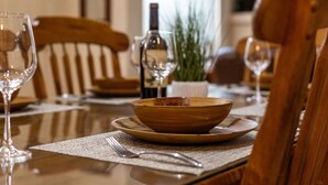 A dining table set with a bowl, wine glasses, and a bottle. - Rim Village X3 - Large Patio & Private Hot Tub (Moab)