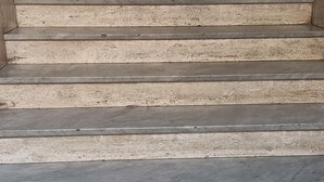 Una scala con ringhiera in legno e corrimano in metallo.