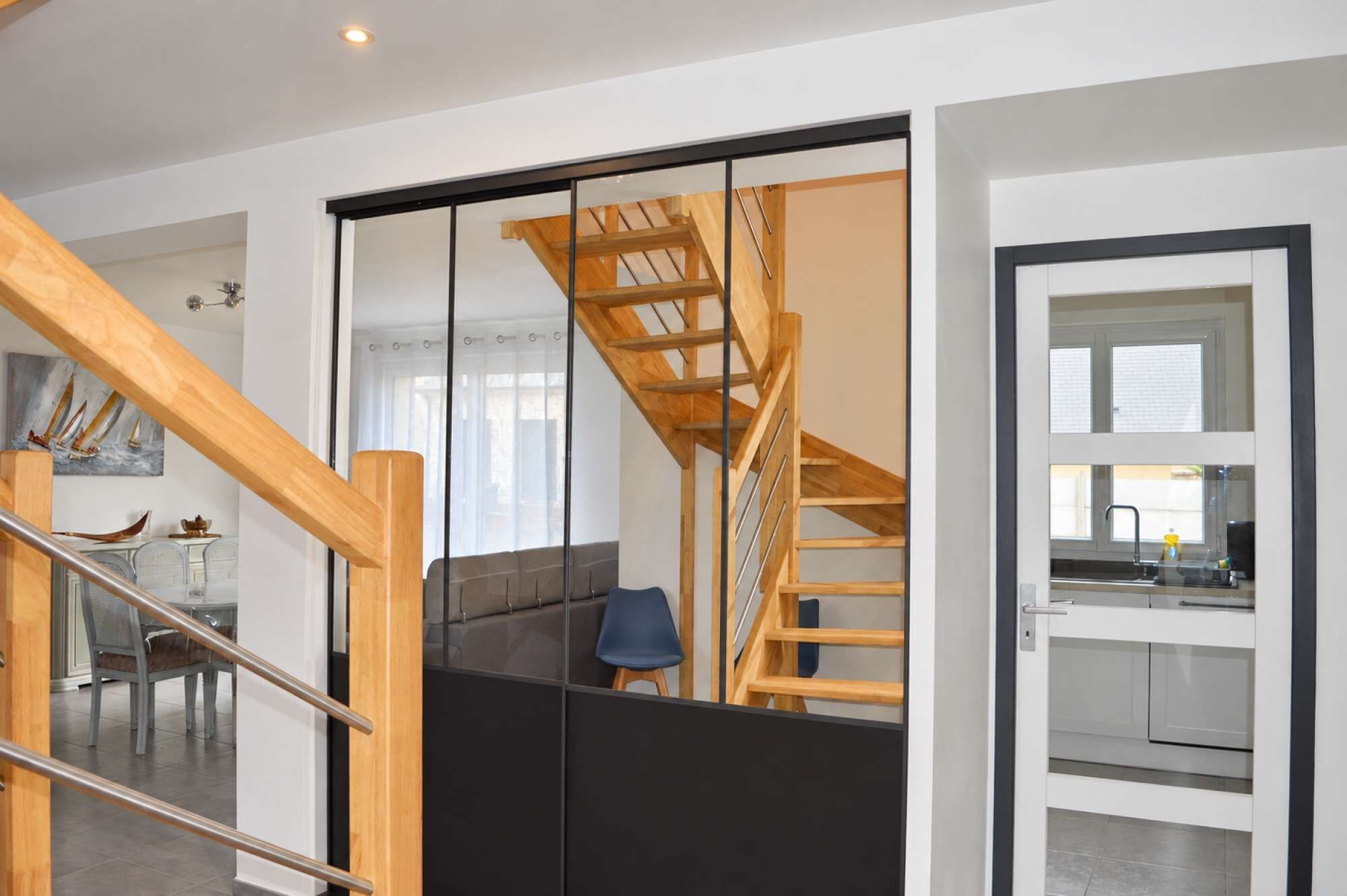 A modern interior with a staircase, a dining area, and a kitchen.