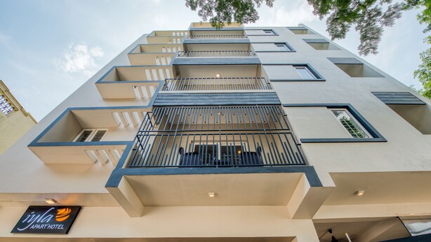 A modern hotel building with multiple balconies, a sign for 'Iyla Apart Hotel', and a gated entrance. - Iyla Apart Hotel (Puducherry)