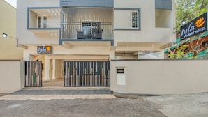A modern building with a gated entrance, a sign for 'Iyla Apart Hotel', and a balcony with railings. - Iyla Apart Hotel (Puducherry)