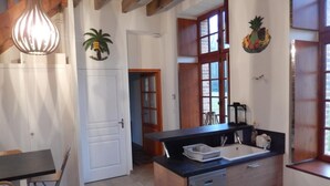 Eine Küche mit einer Holzausziehtafel, einem Geschirrspüler und einem Fenster mit Blick ins Freie.