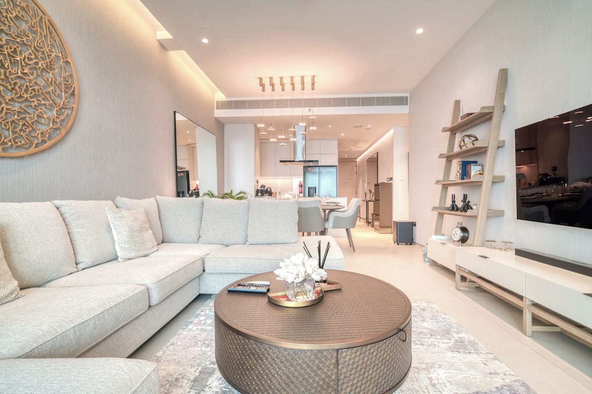 A modern living room with a sectional sofa, a coffee table, and a TV.