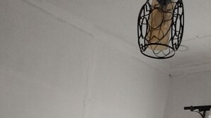 A bed with white bedding, a dark headboard, and a brown pillow. - Amazon one bedroom apartment  (Nakuru)