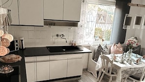 A kitchen with white cabinets, a black countertop, and a window providing natural light.