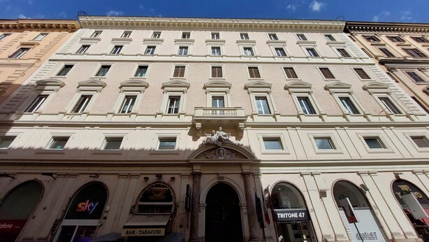 A multi-story building with a classical architectural style, featuring a central entrance with a decorative pediment and a balcony. - Treasurerome Spanish Steps Family 4BR (Rome)
