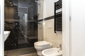A modern bathroom with a glass-enclosed shower, a toilet, and a sink. - Trastevere 143 (Rome)