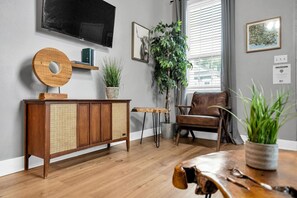 Relax in a tastefully decorated living room with a leather armchair, dining table, and flat-screen TV.