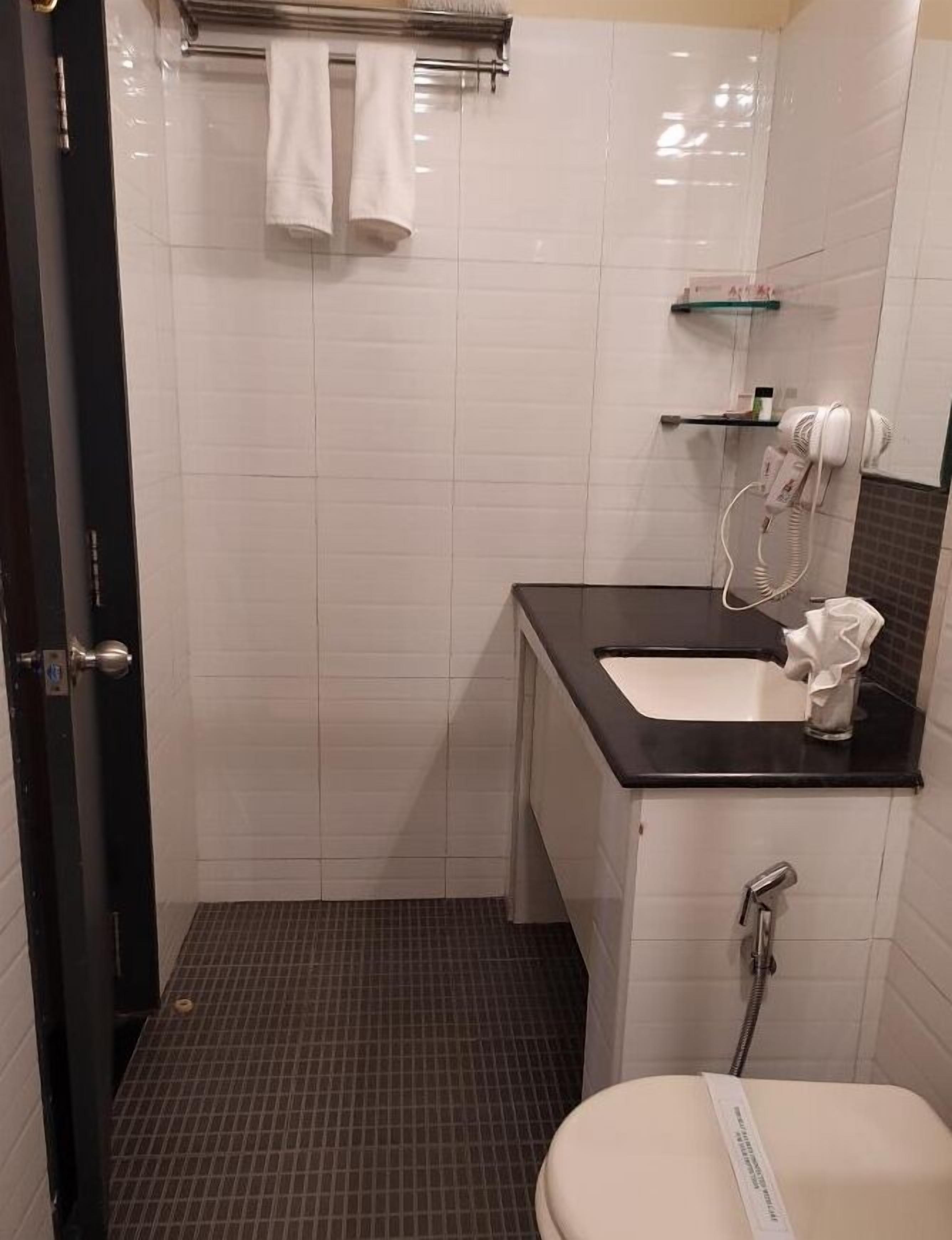A bathroom with a shower, toilet, and sink.