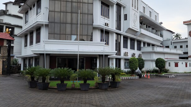 A multi-story hotel with a prominent sign reading "Hotel Merlin International". - Hotel Merlin Interantional (Thrissur)