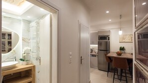 Cozinha moderna com geladeira, micro-ondas e área de jantar com banquetas.