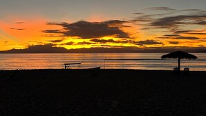 A beach at sunset with a thatched umbrella and a ladder. - BAY FRONT HOME WITH AMAZING VIEWS.  MINUTES TO THE BEACH AND STEPS TO THE POOL  (Fenwick Island)