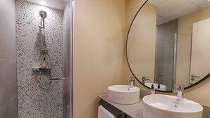 A modern bathroom with a freestanding shower, two sinks, and a large mirror. - Appartement Pour six Personnes (Plescop)