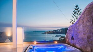 A hot tub with a view of the sea and a stone wall. - My Rental Homes - Villa Sonia with pool, Jacuzzi bathtub, sea view (Platis Gialos)