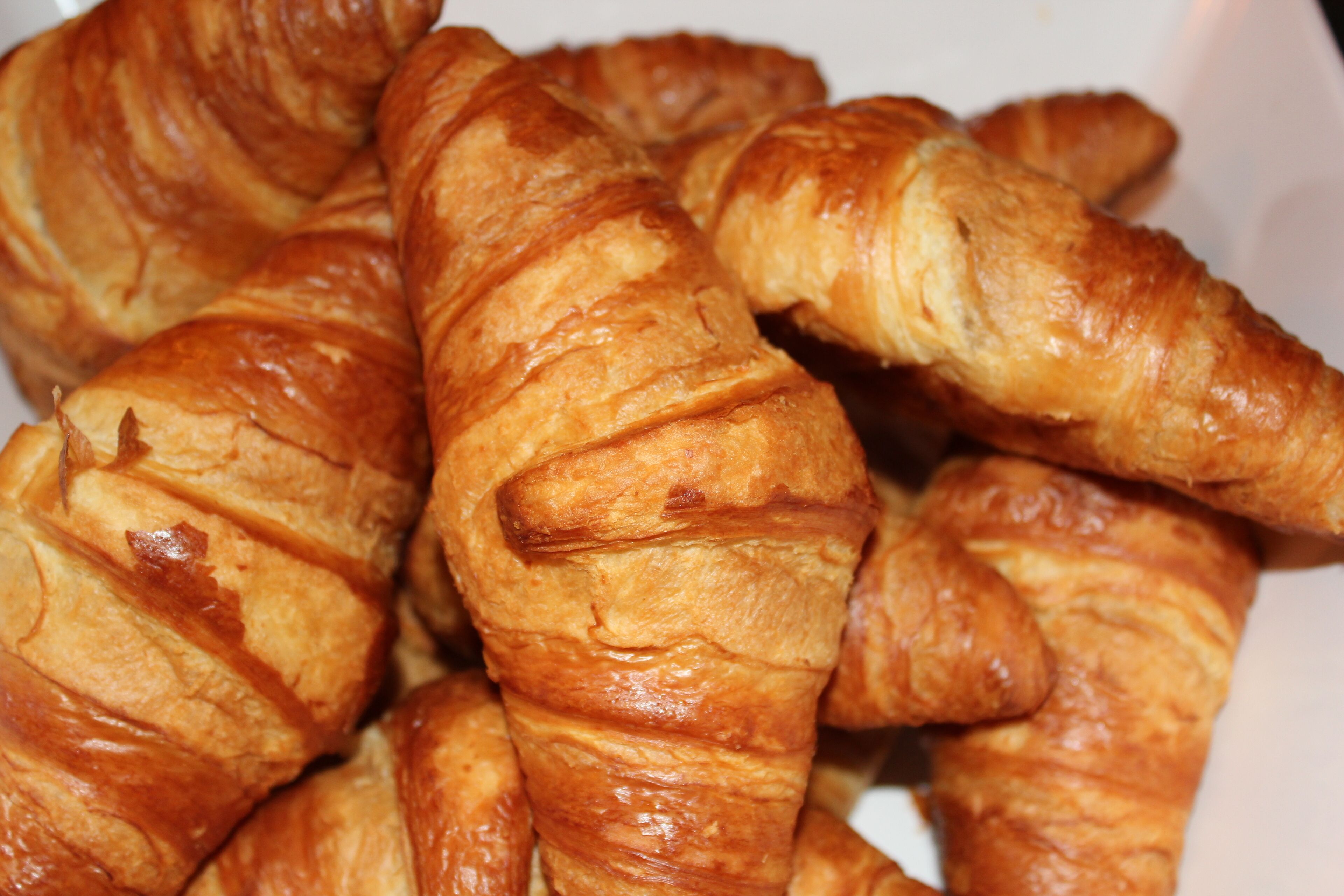 Un gros plan de croissants dorés et bruns, empilés les uns sur les autres.