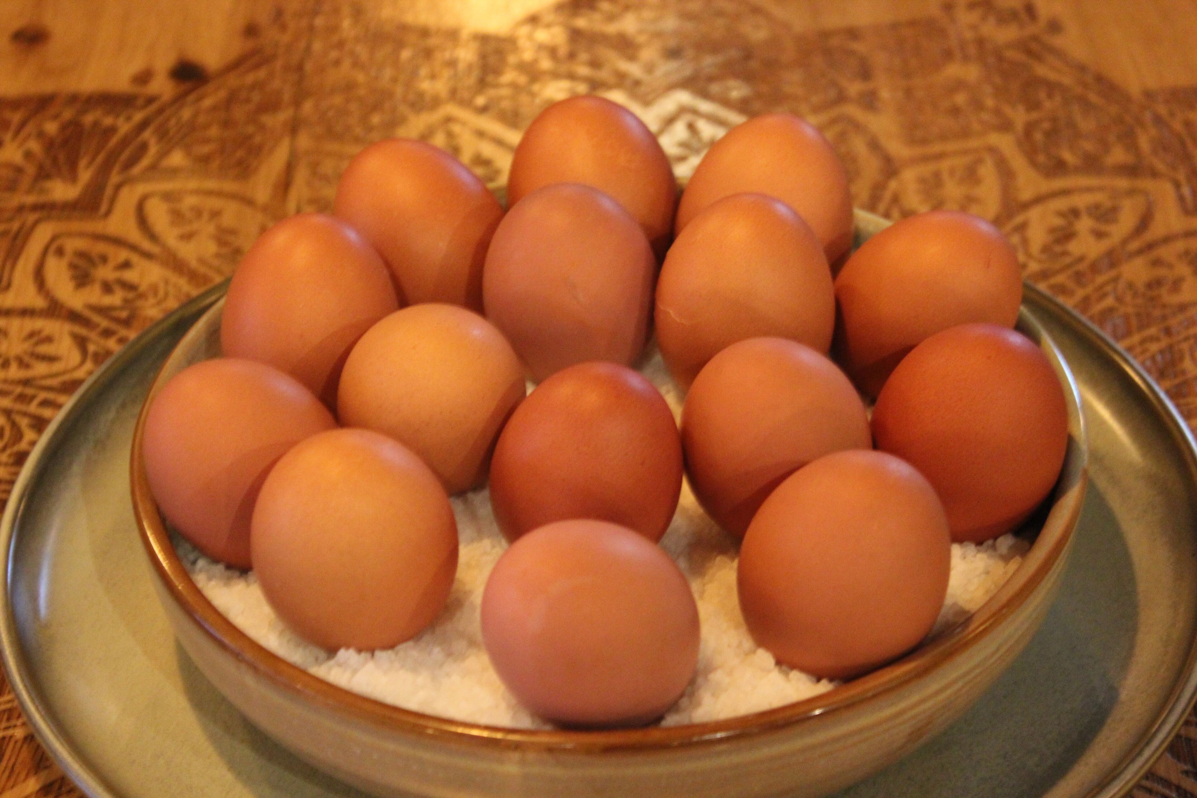 Un tazón de huevos sobre un mantel estampado.
