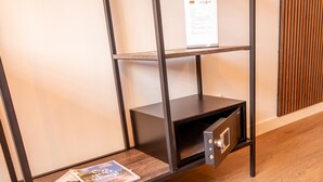Una estantería de metal con un mueble con cerradura, una revista en el estante inferior y un letrero en el estante superior.