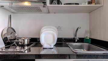 Una cocina compacta con microondas, cafetera y horno empotrado.