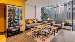 A modern interior with a vending machine, sofas, a coffee table, and a large window. - DAS HAUS  (Bogotá)