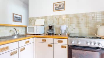 Een koffiezetapparaat/waterkoker, een koelkast, een magnetron, een oven