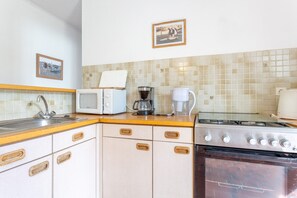 Een koffiezetapparaat/waterkoker, een koelkast, een magnetron, een oven