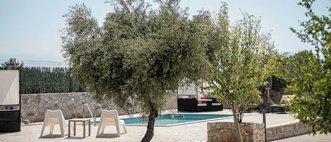 Piscine extérieure en saison, parasols, chaises longues