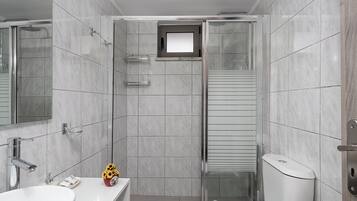 A modern bathroom with a shower, toilet, and sink.