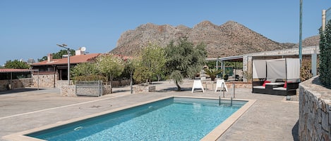 Una piscina al aire libre de temporada, sombrillas