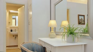 A room with a white vanity, two lamps, a chair, and a potted plant. - Treasurerome Opera Trevi Green Suite 2BR (Rome)