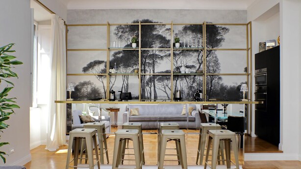 A modern living room with a grey sofa, a coffee table, and a dining area with stools. - Treasurerome Quattro Fontane Luxury (Rome)