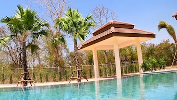 Una piscina al aire libre, sillones reclinables de piscina