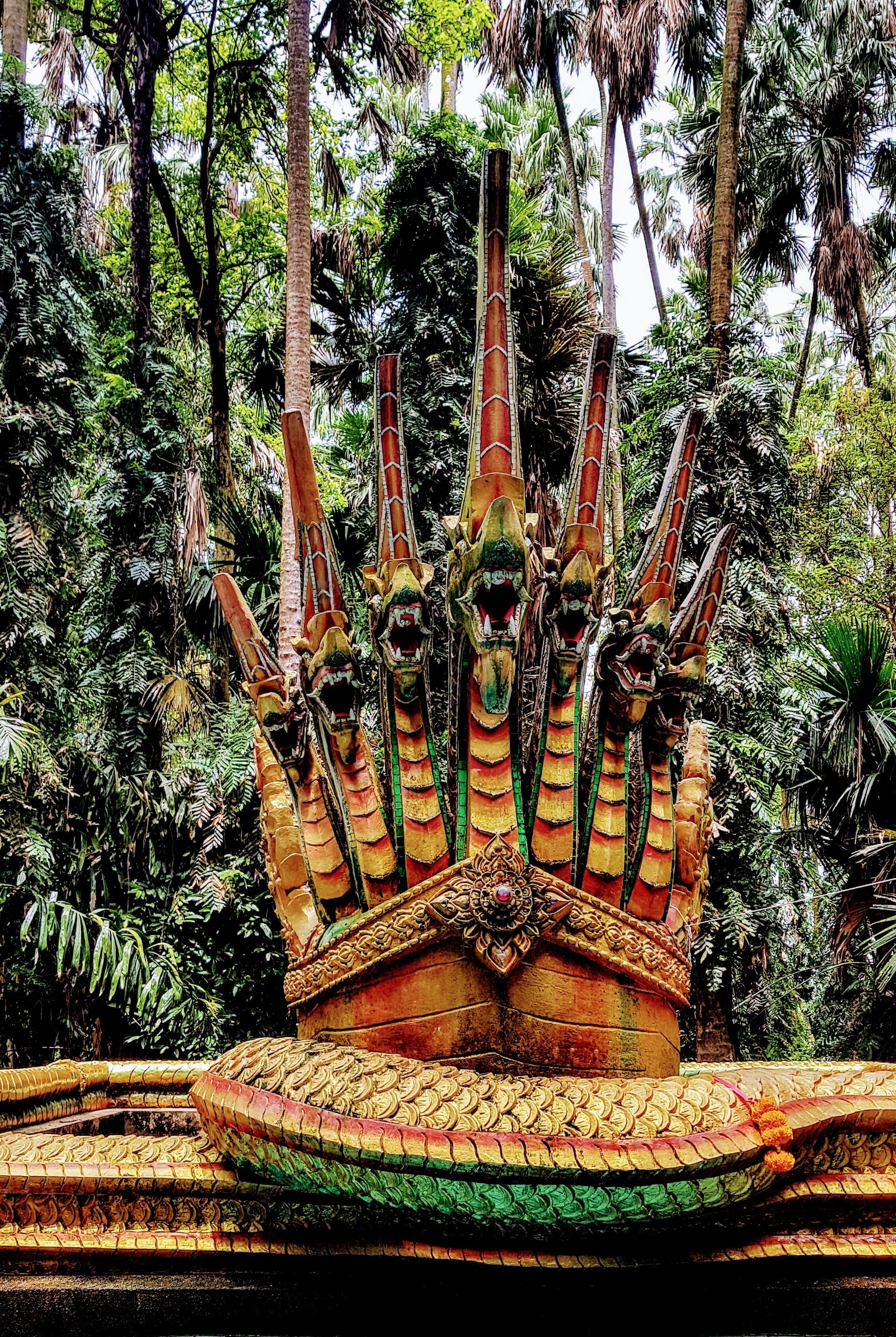 Una estructura grande y ornamentada con múltiples agujas, rodeada de densa vegetación tropical.