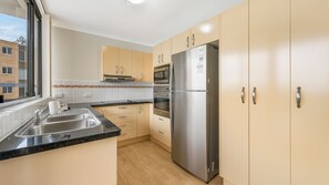 A modern kitchen with a stainless steel refrigerator, double oven, and a built-in microwave.