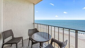 A balcony with wicker furniture and a view of the ocean.