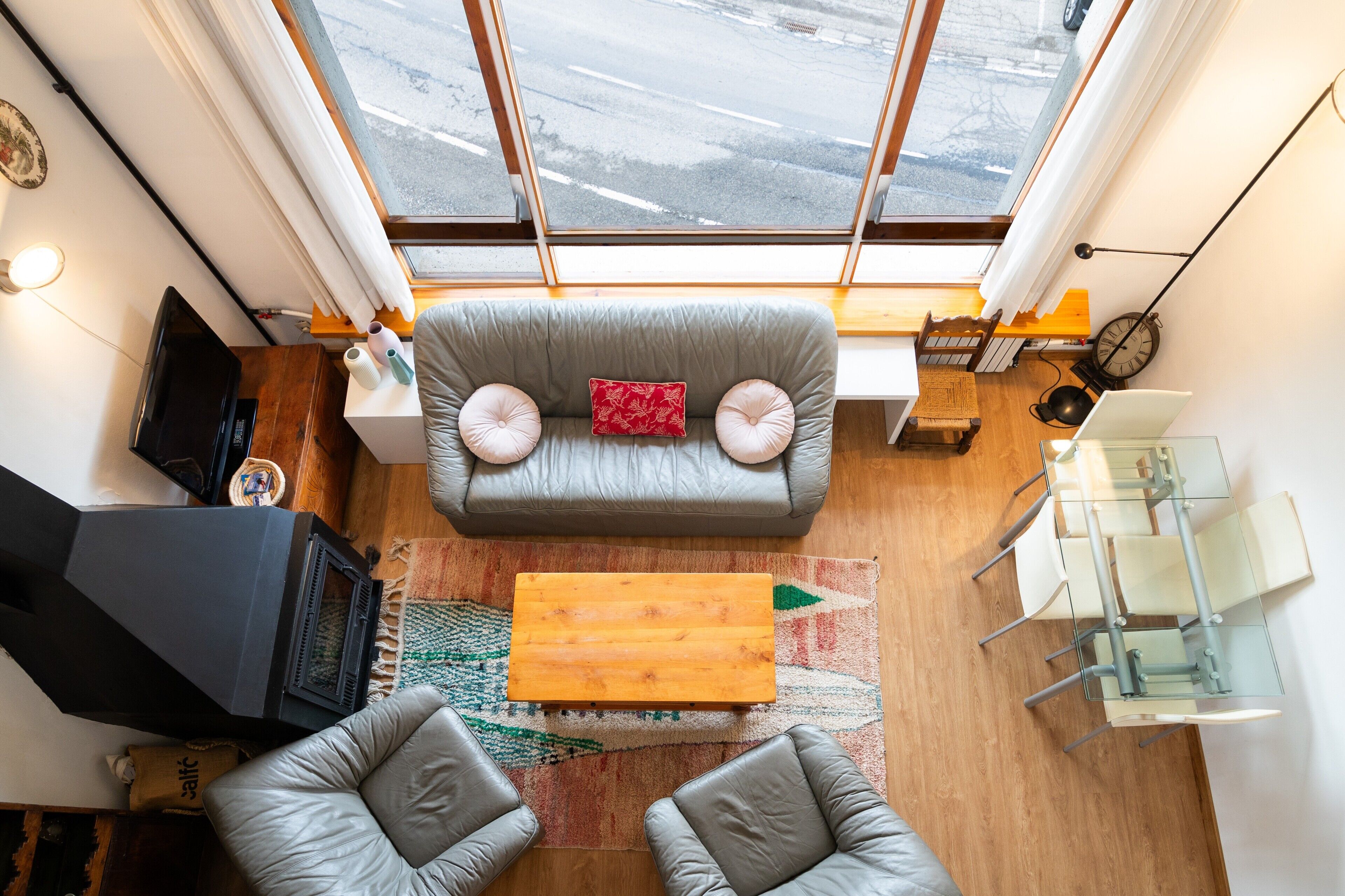 Una sala de estar moderna con un sofá, sillas, televisor, chimenea y comedor.