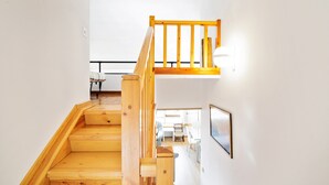 A wooden staircase with a black railing leading to an upper floor. - Apartment 'Masella' with Mountain View, Shared Garden (Masella)