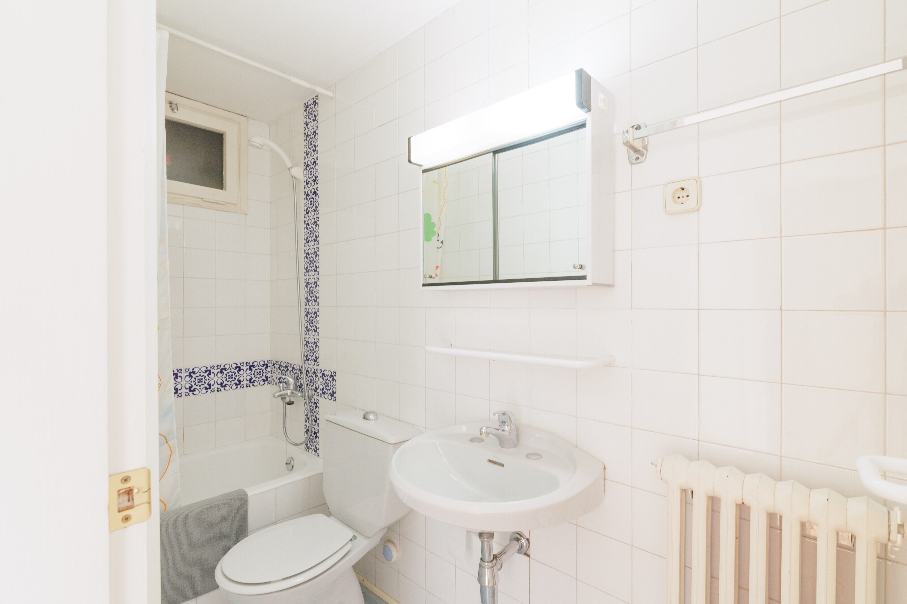 Un baño con inodoro, lavamanos, ducha y espejo.