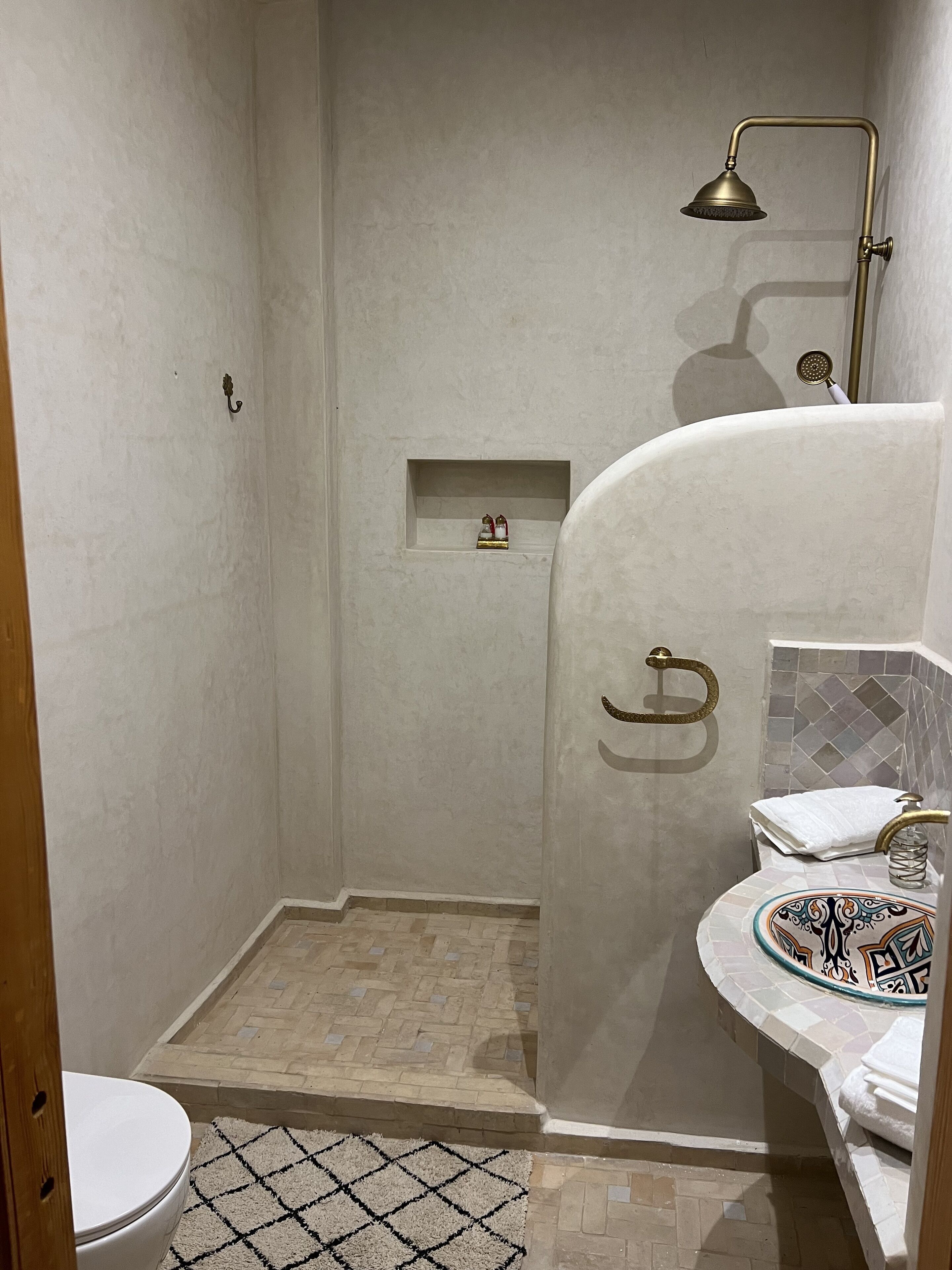 A bathroom with a shower, toilet, and sink.