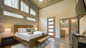A bedroom with a wooden bed, a bench, a nightstand, and a dresser. - NEW Cozy Lux Cabin! *VIEWS* Hot Tub,Wi-Fi-Sleeps 8 (Broken Bow)