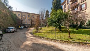 A gravel driveway leading to a building with parked cars. - Casa Carolina (Pavia)