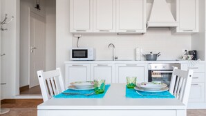 A modern kitchen with white cabinets, a microwave, a sink, and a stove. - Casa Carolina (Pavia)