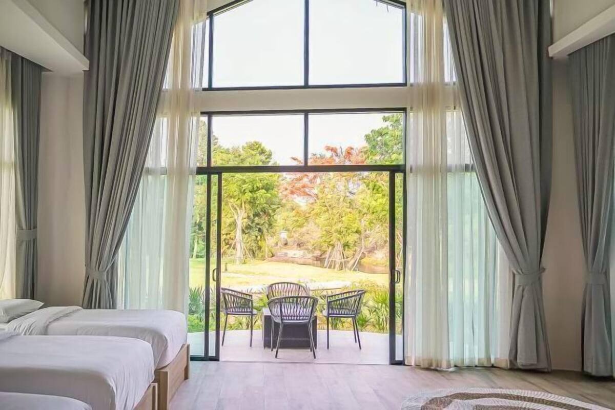 A bedroom with a large sliding glass door leading to a patio with a table and chairs.
