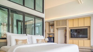 Una habitación de hotel moderna con una cama grande, un televisor de pantalla plana montado en la pared y un armario de madera integrado.