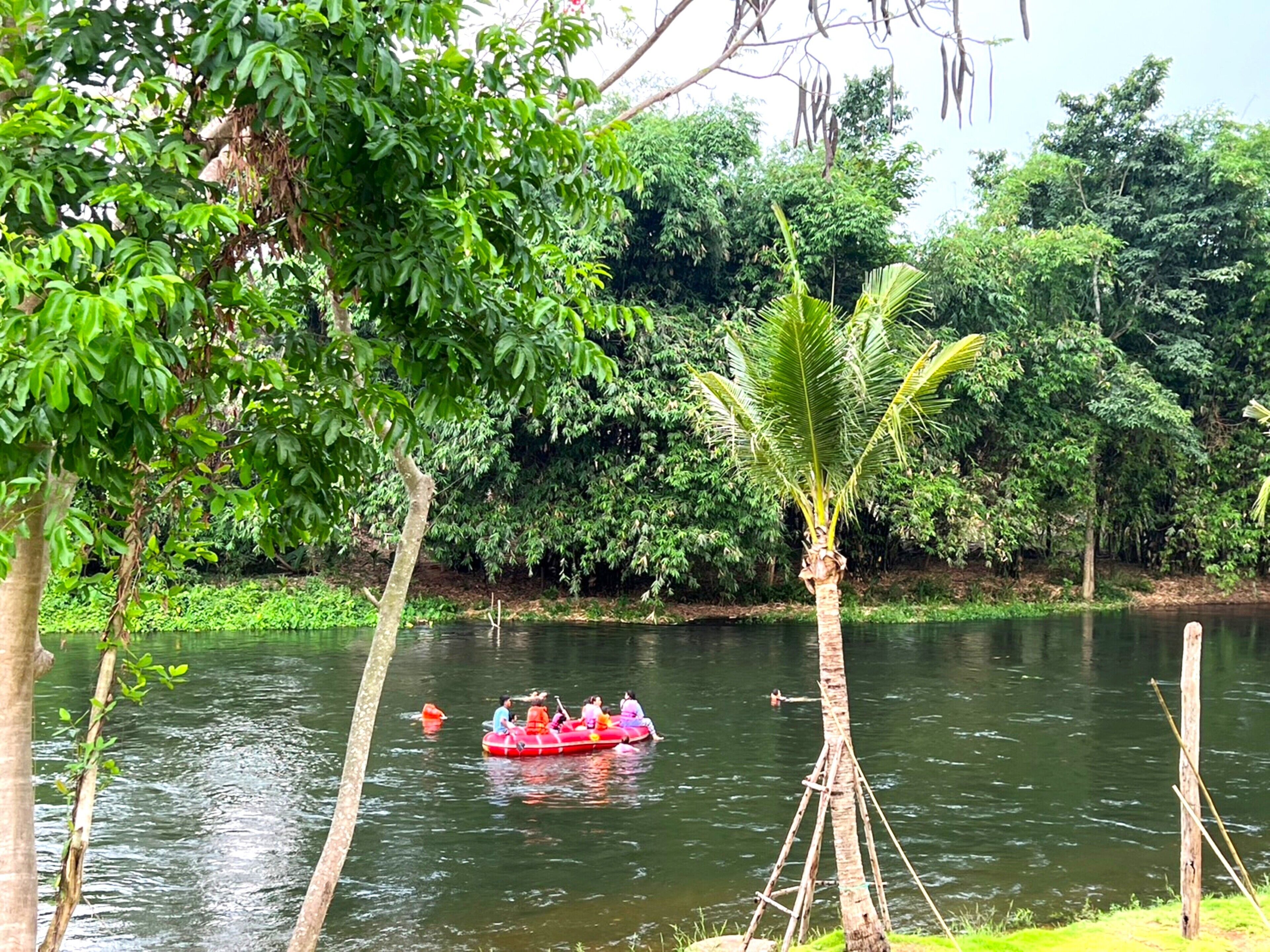 Une rivière où l’on voit un groupe de personnes dans un radeau rouge.